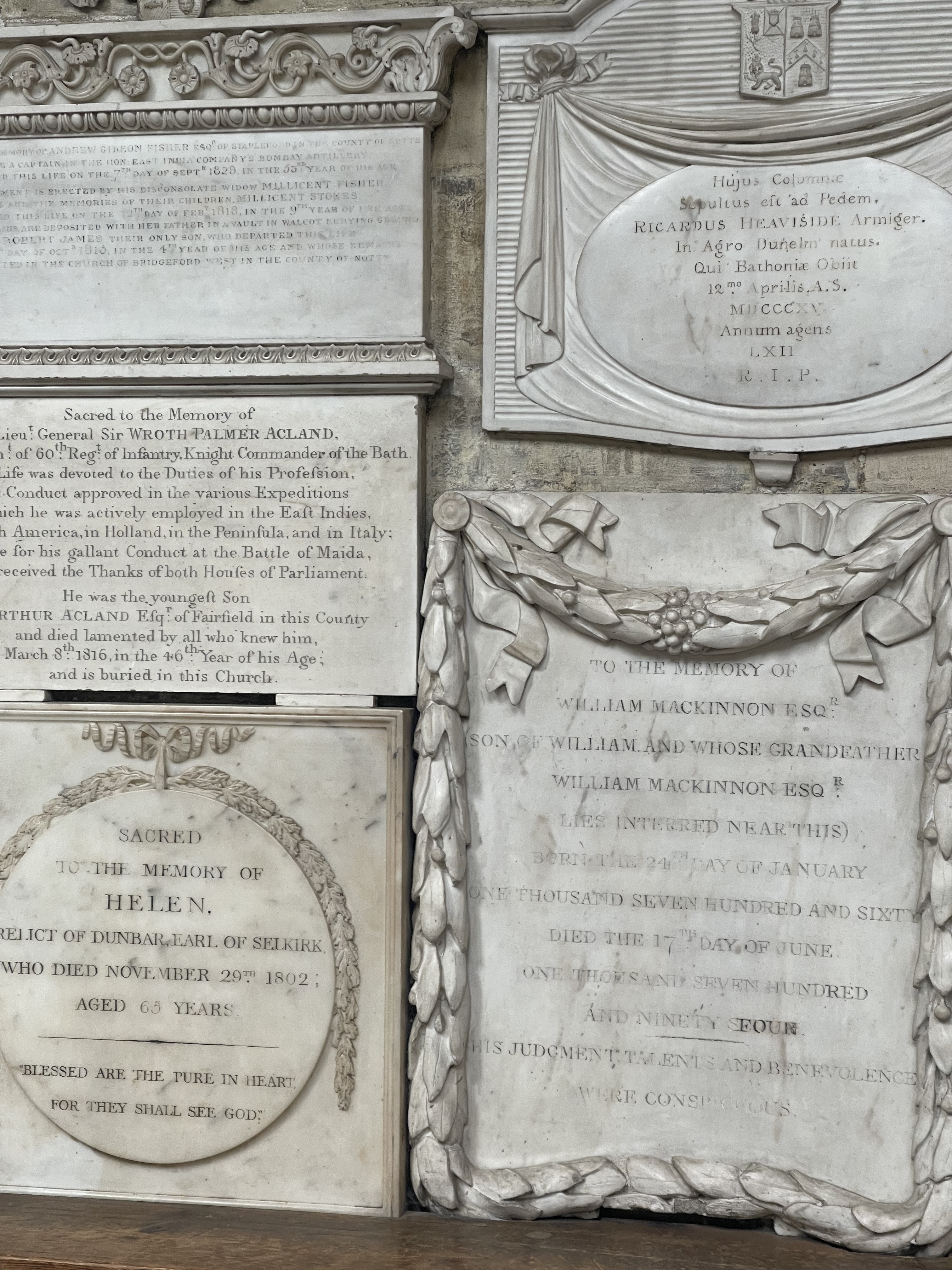 Carved marble memorial tablets covering a wall in Bath Abbey