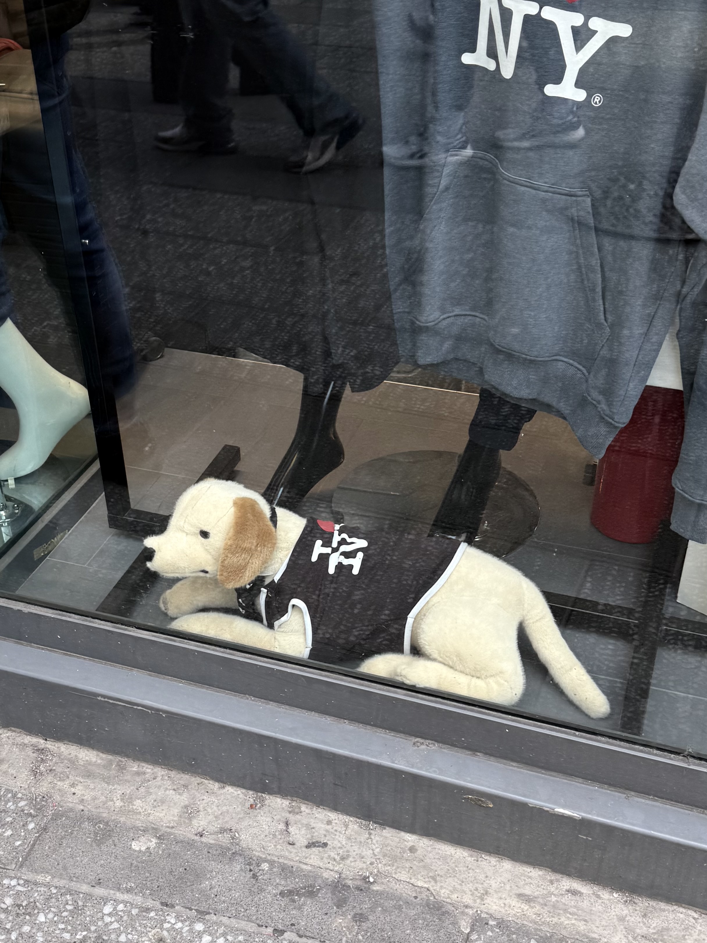A plush white dog in an I love NY T-shirt in a Times Square shop window