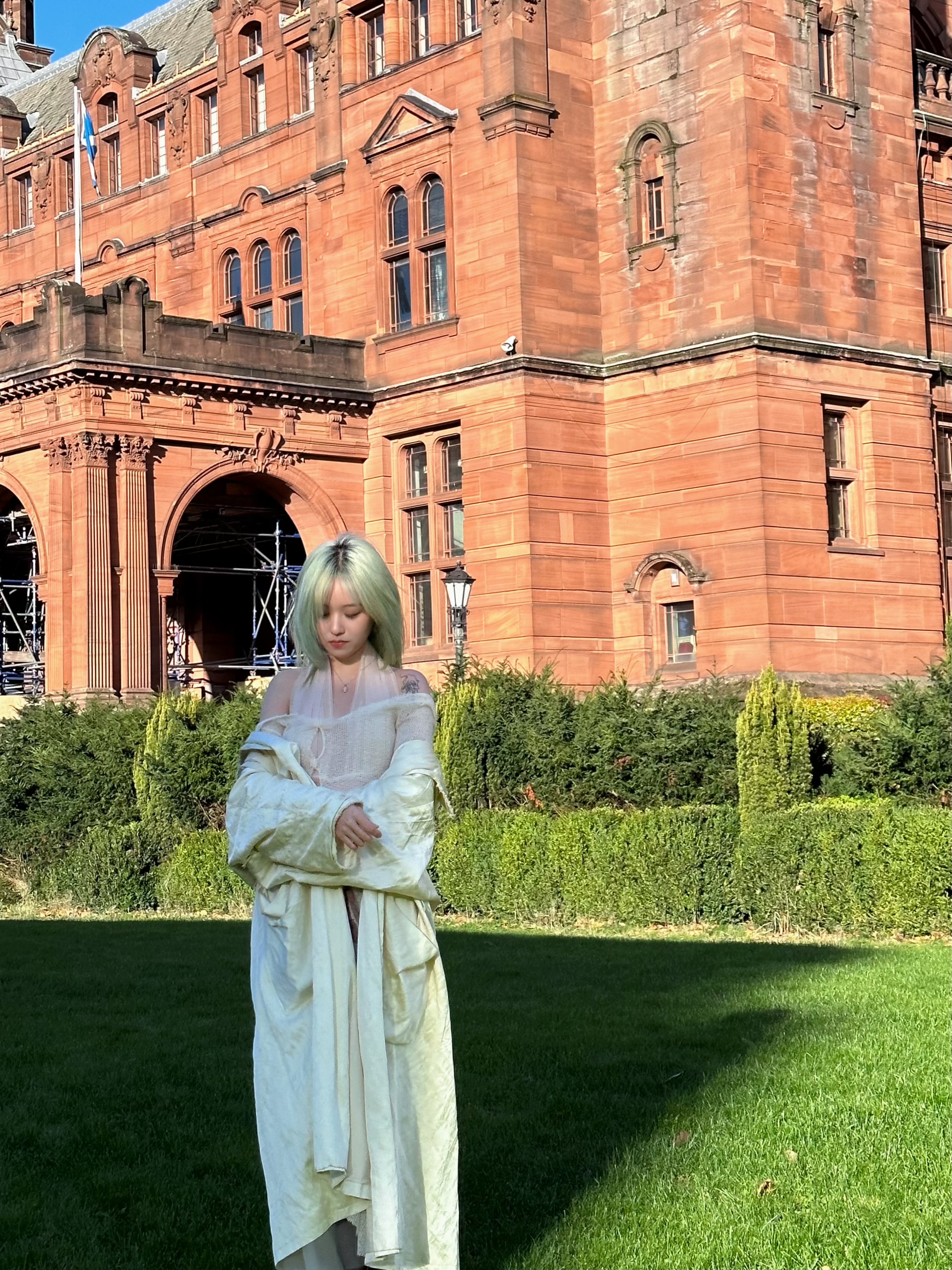 Violet standing on the lawn in front of the red sandstone Kelvingrove Art Gallery and Museum in Glasgow